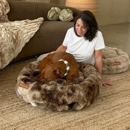 Luxurious faux-fur donut bed with a dog curled up in it