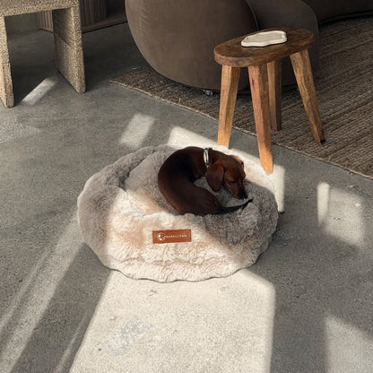 Luxurious faux-fur donut bed with a dog curled up in it